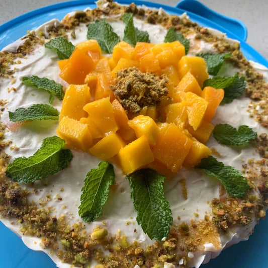 This Saffron Mango Pistachio Tres Leches Cake decorated with fresh mango and mint to look like a blossom opening