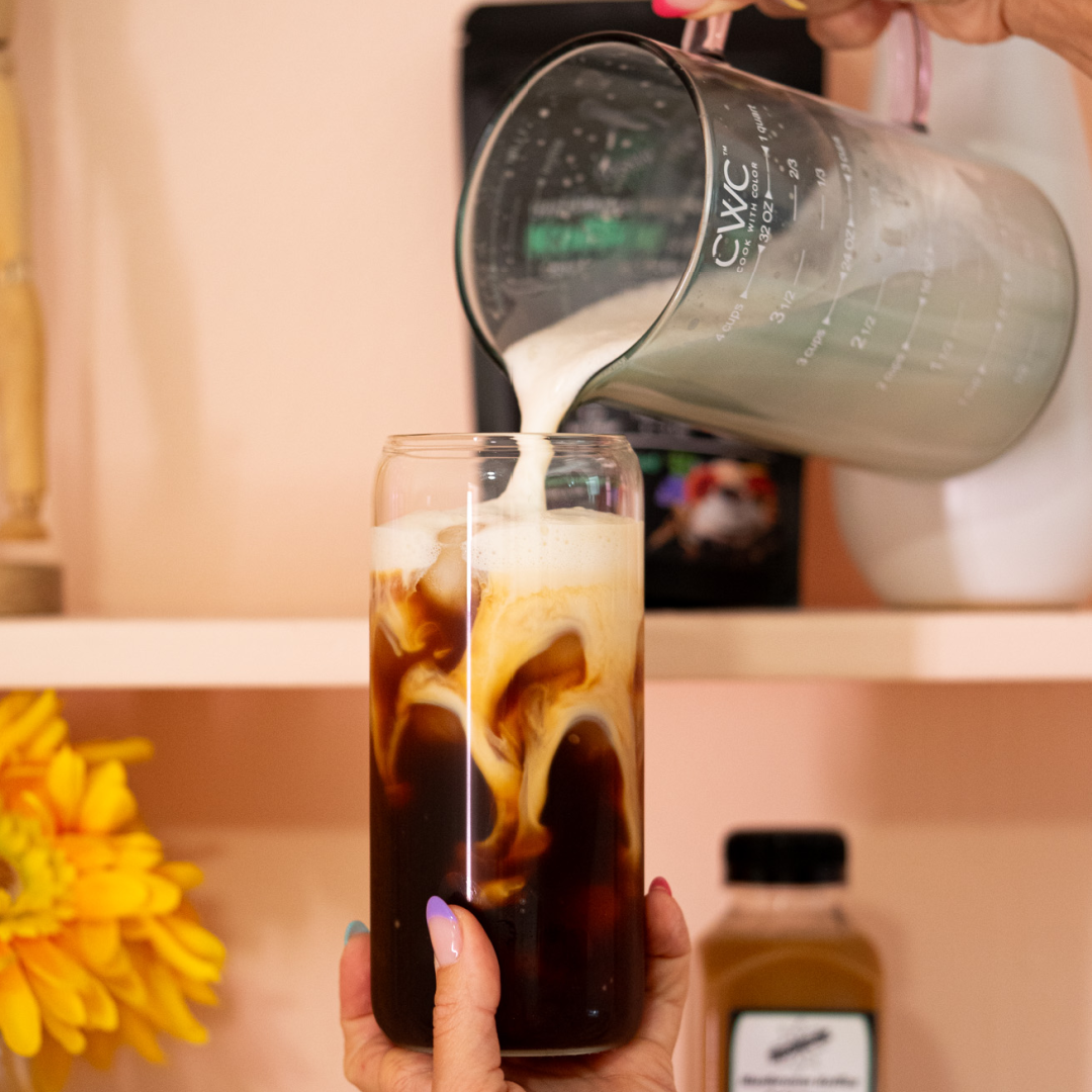 Frothed milk being poured into a Koffee cold brew for a caffeine-free coffee alternative made from mushrooms and herbs