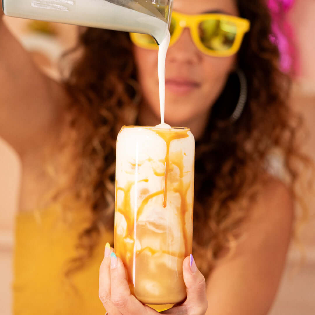 Iced mushroom koffee latte with creamy milk pour and caramel drizzle for a wellness ritual